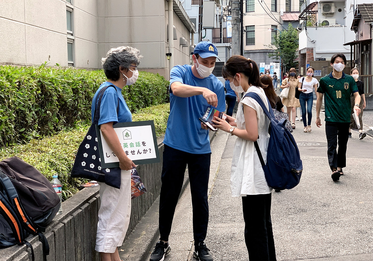 Pierce Hite, center, a Southern Baptist Convention International Mission Board missionary serving in Tokyo, Japan, explains a gospel tract to a woman, July 20, 2021. Hite and missionary Julie Bradford, left, took part in an outreach event called 5-Minute English that provides opportunities for people to practice conversational English on the street.  This photo is being used for non-commercial purpose and not in connection with selling a good or service.
